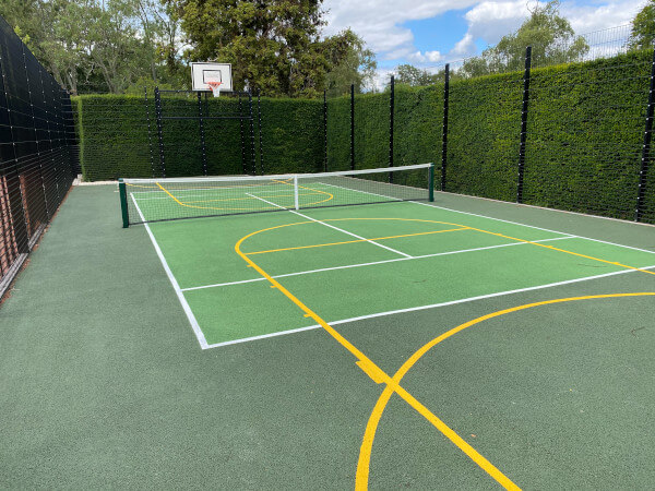 tennis court surrounded by a headge
